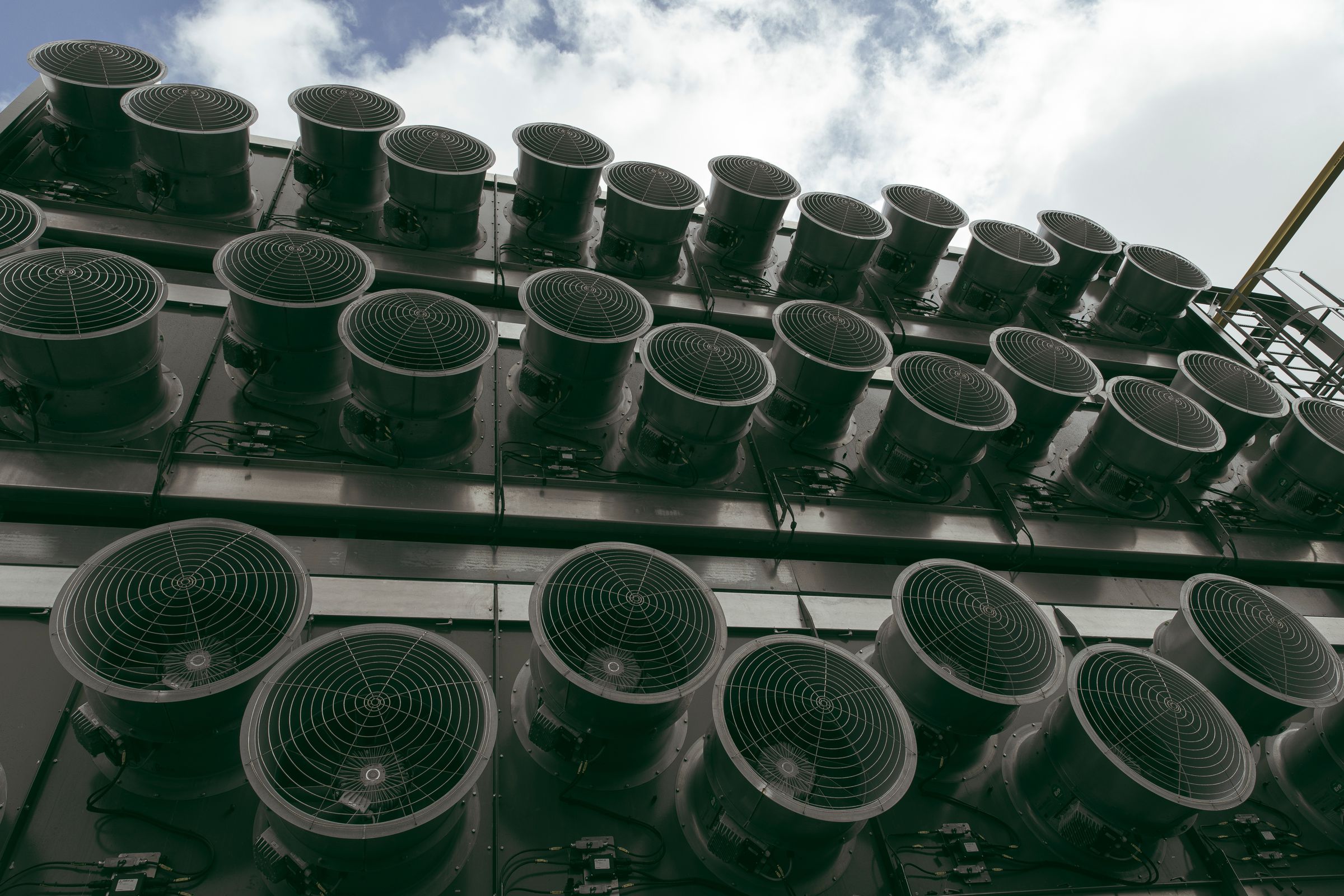 Rows of fans seen on the facade of an industrial plant.