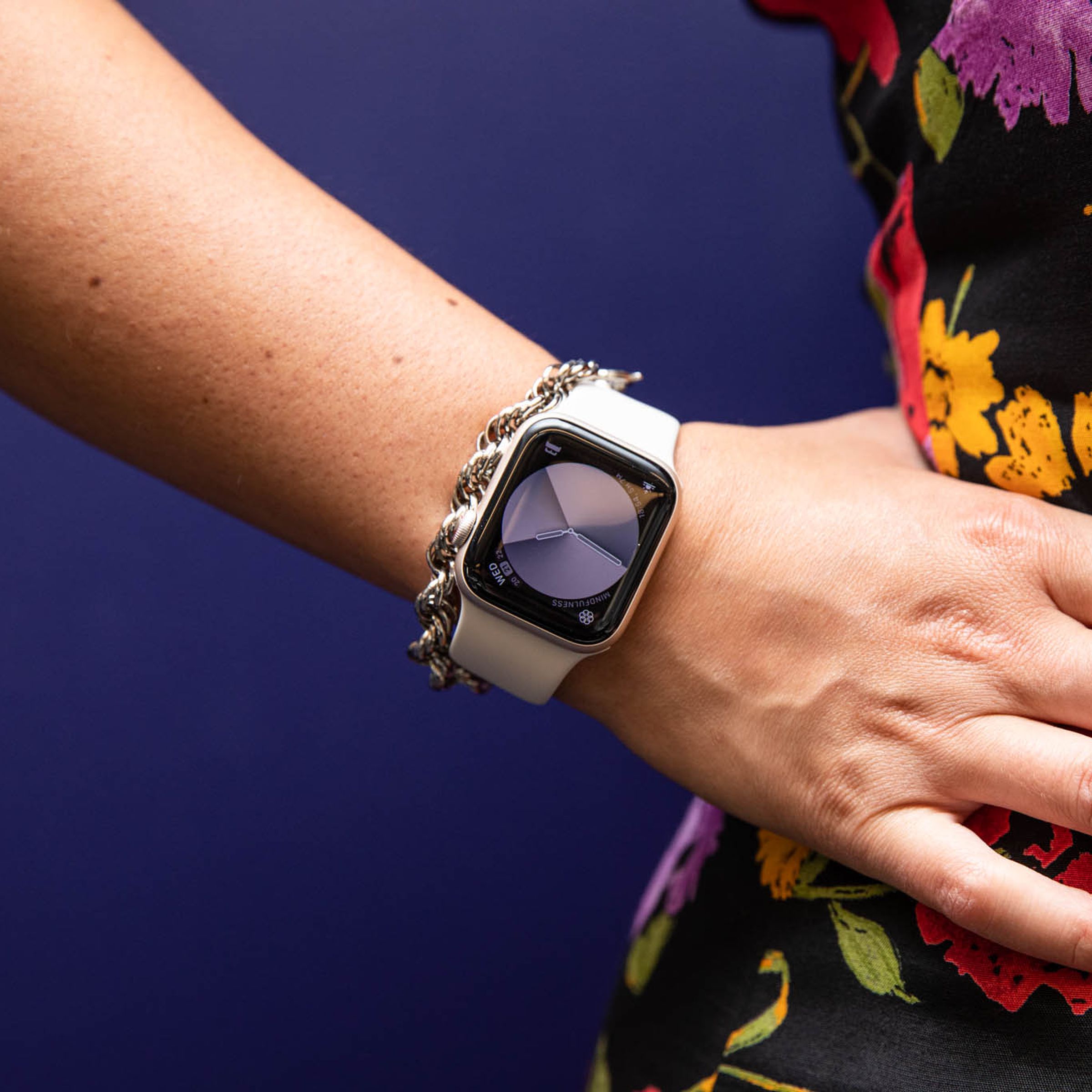 Woman in floral dress with hand on hip modeling Apple watch SE (2022)