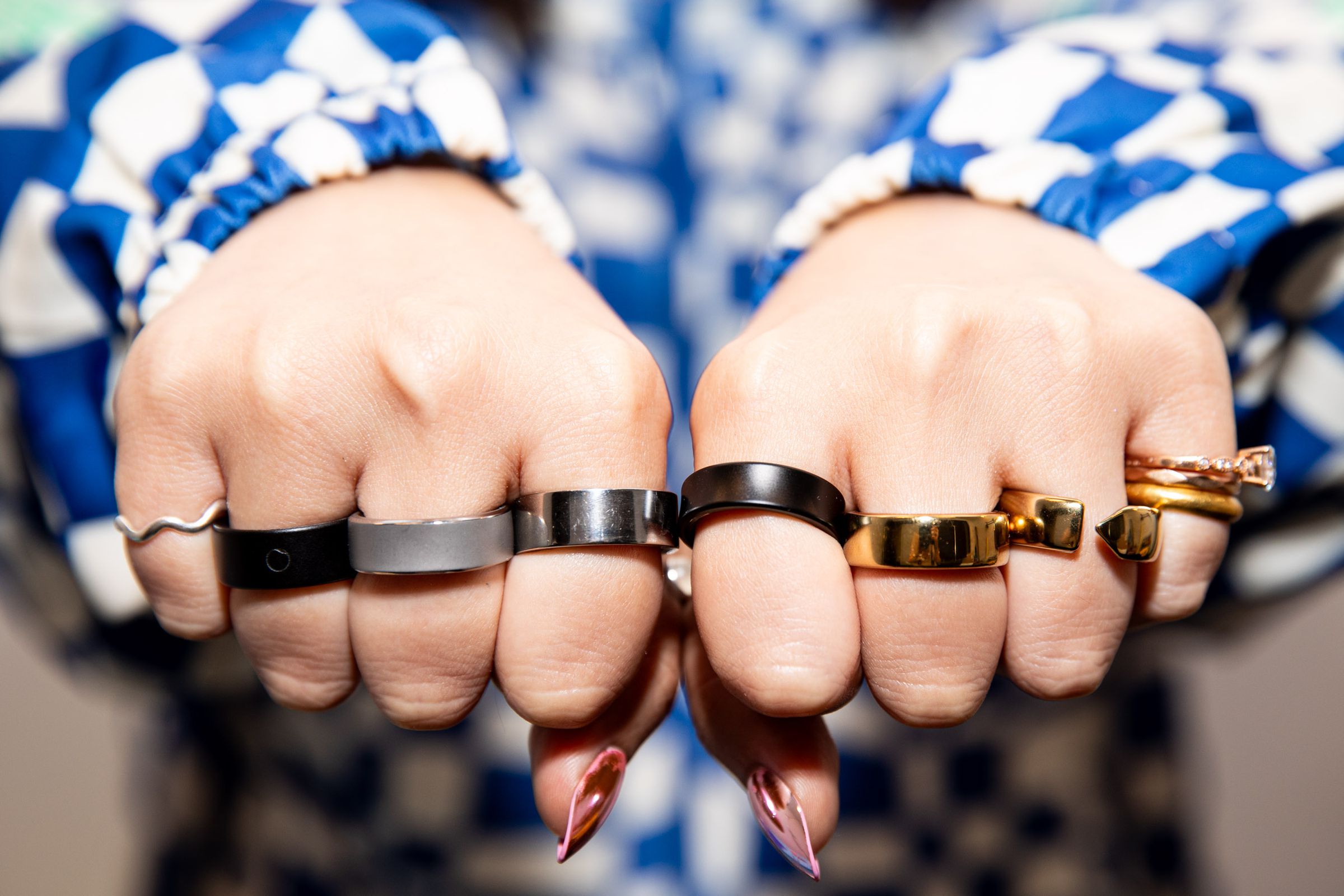 Person wearing six smart rings with their fists forward