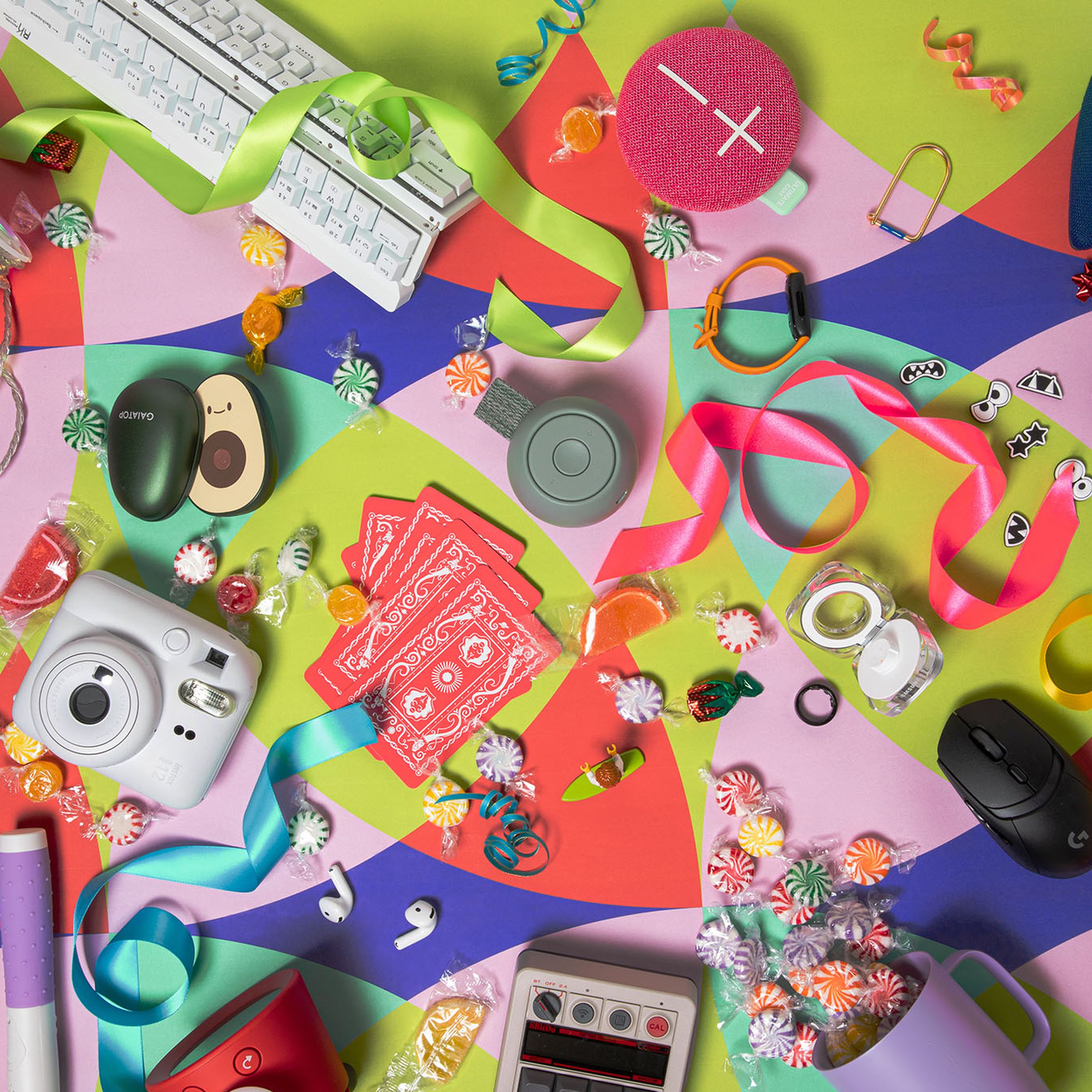 Photograph of brightly colored gifts scattered on a graphic background of vibrant patterned paper.