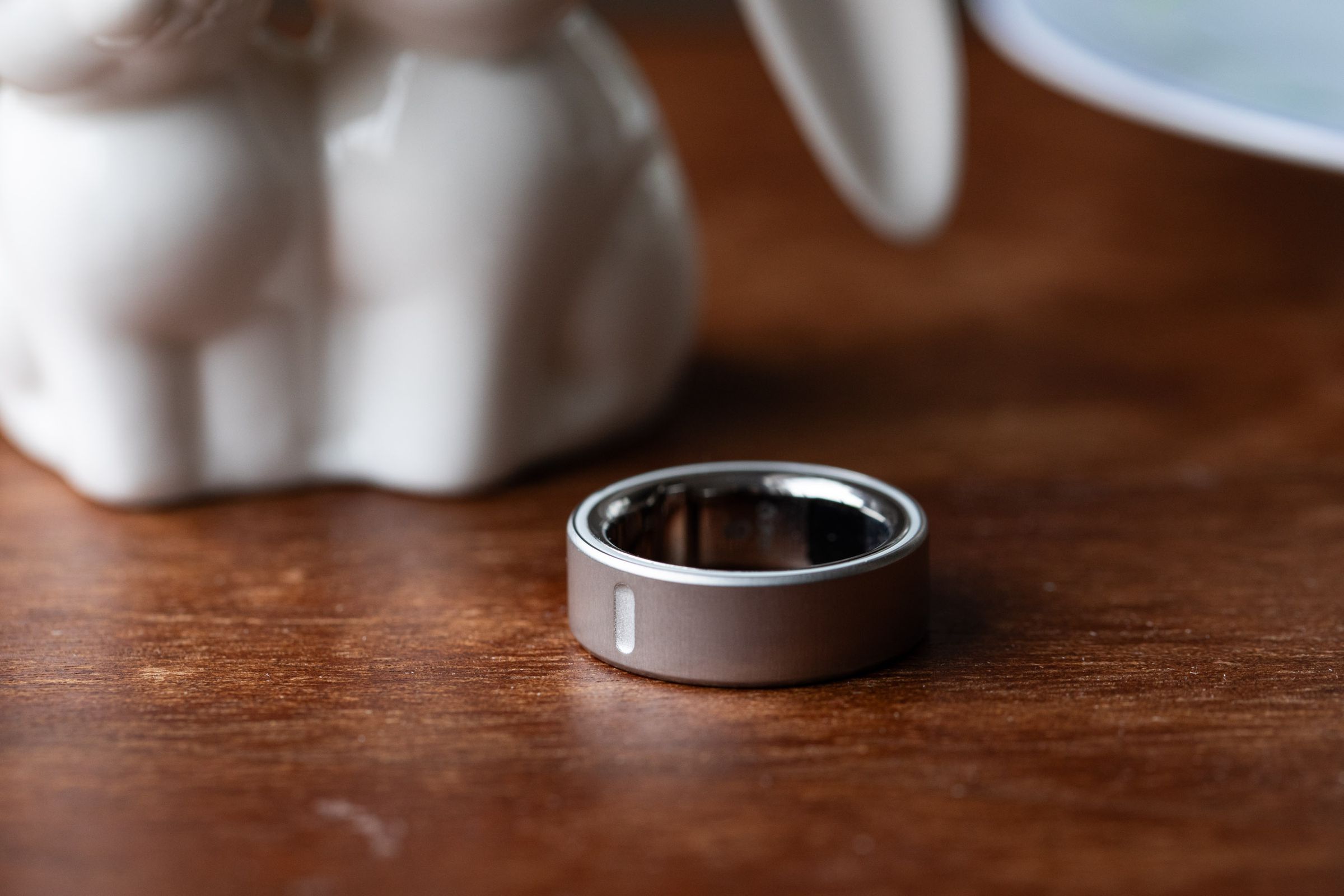 Close up of silver Oura Ring 4 on a wooden surface