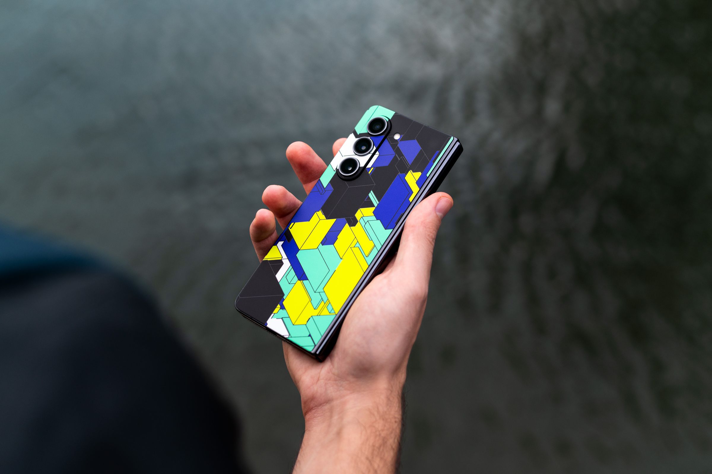 Galaxy Z Fold with a Verge dbrand skin in someone’s hand