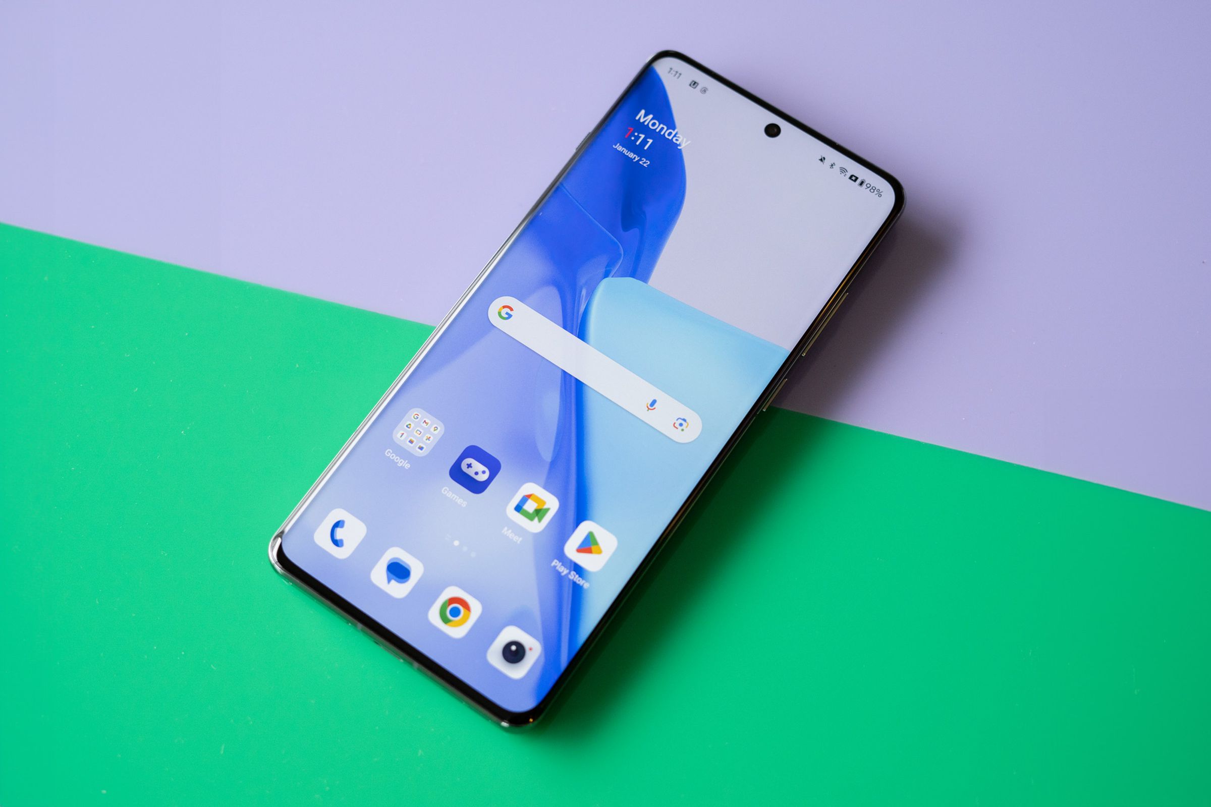 OnePlus 12 on a green and purple background showing home screen.