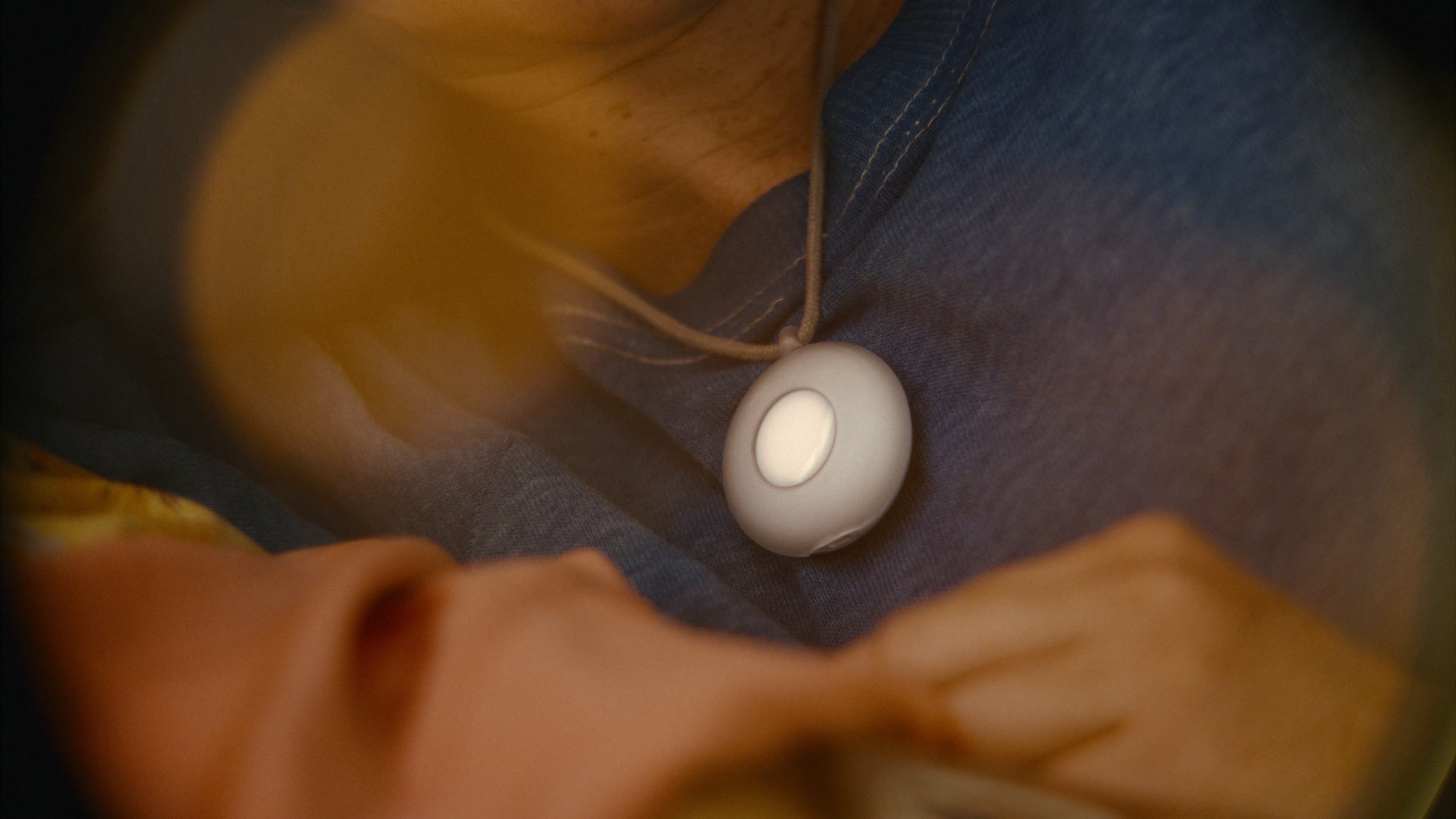 A mock-up of the Friend pendant. It’s a small white puck on a necklace.