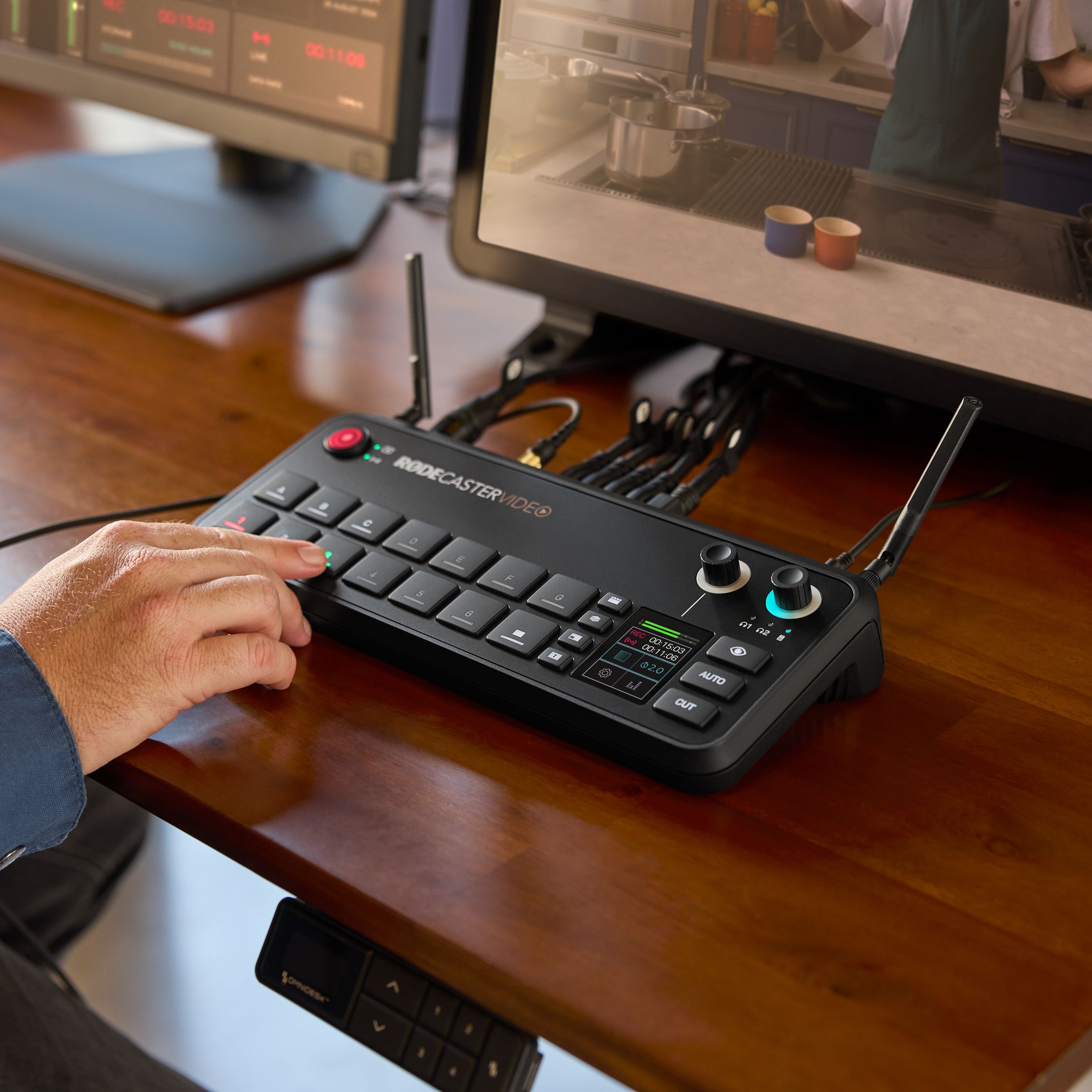 The Rodecaster Video on a table, a person pressing on of the buttons.