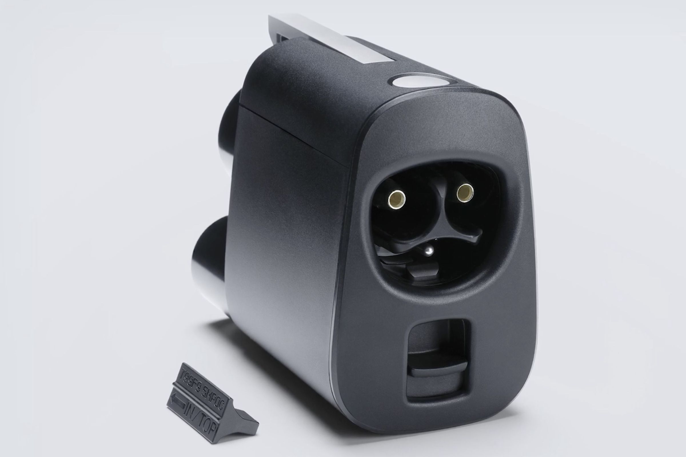 a Tesla NACS adapter with a plastic tab next to it