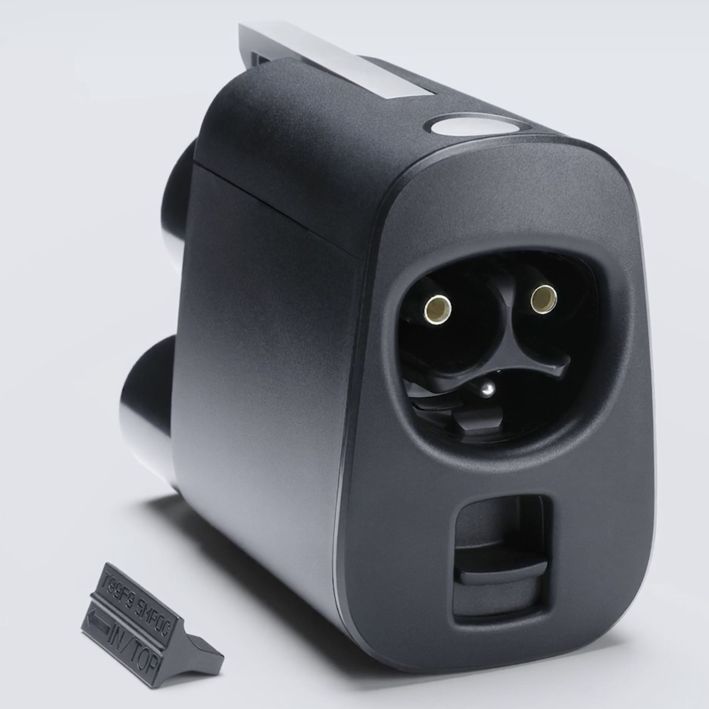 a Tesla NACS adapter with a plastic tab next to it