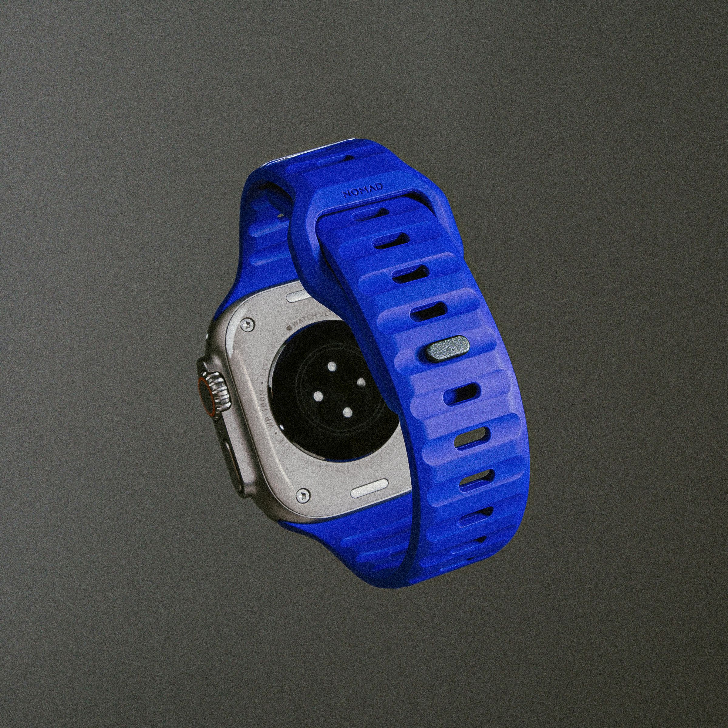 The Verge x Nomad blurple Apple Watch band on an Apple Watch Ultra floating on a gray background