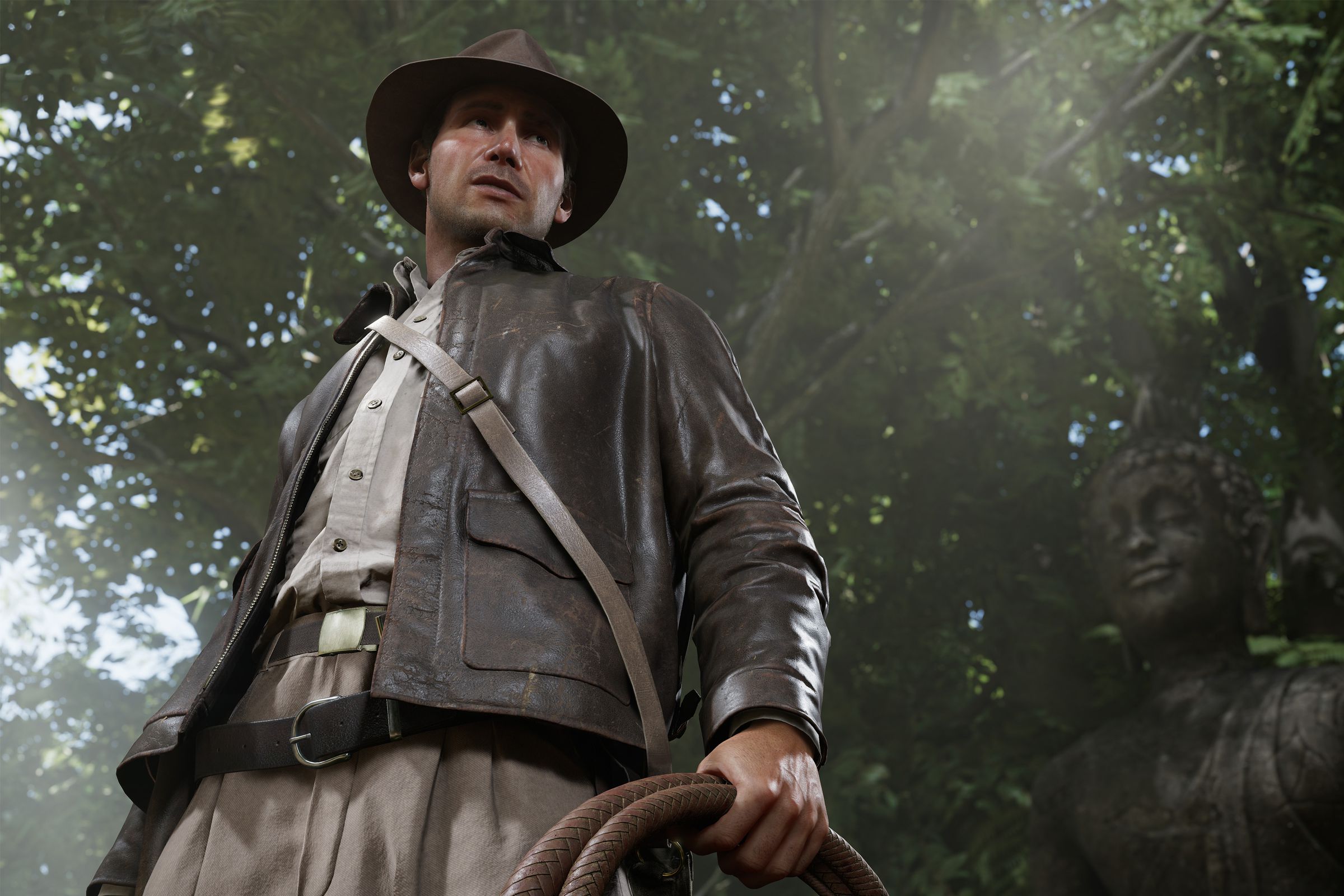 Screenshot from Indiana Jones and the Great Circle featuring a shot of Indiana Jones a white male wearing a brown leather jacket and brown leather hat standing in front of a Buddhist statue.