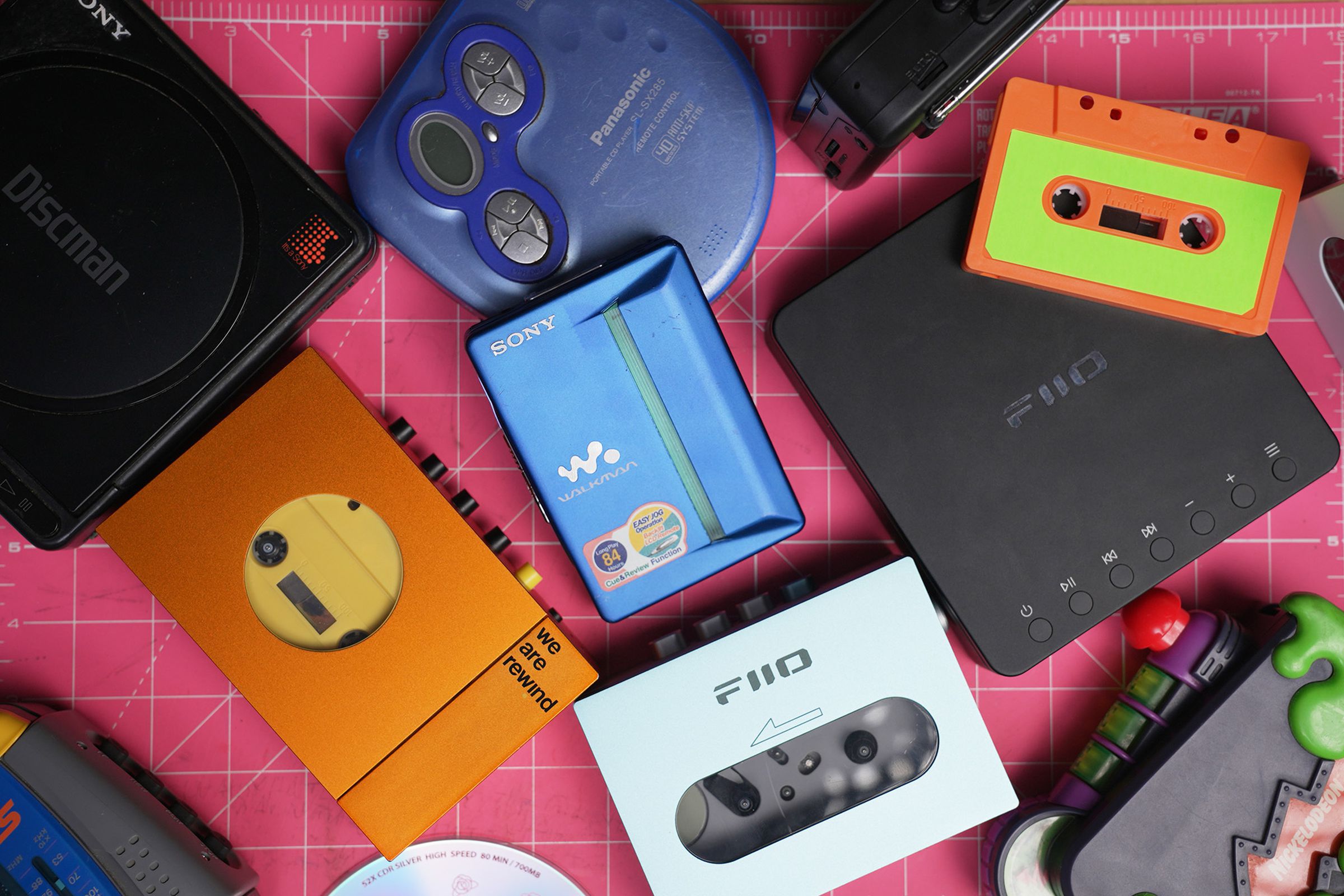 A bunch of cassette players and CD players on a table, including new models from Fiio and We Are Rewind.